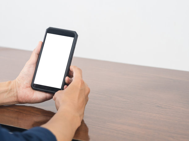 特写手机白屏空白在男人的手放在桌子上图片下载