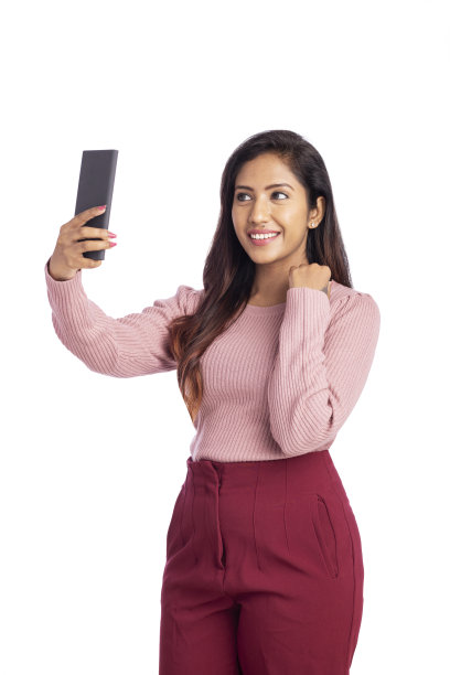 快乐的年轻女子用智能手机自拍图片下载