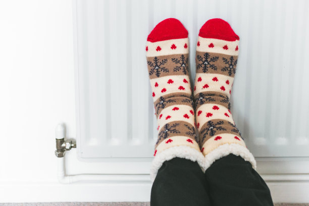 穿着冬天的袜子在暖气片上暖脚图片下载