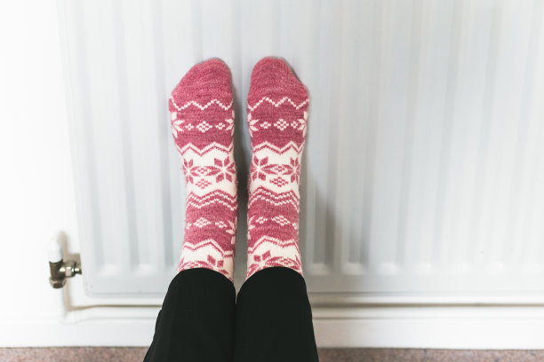 穿着冬天的袜子在暖气片上暖脚图片下载