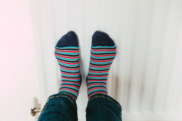 穿着条纹袜在暖气片上暖脚图片下载