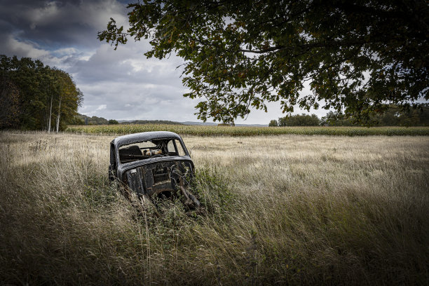 田里一辆生锈的废弃汽车图片下载