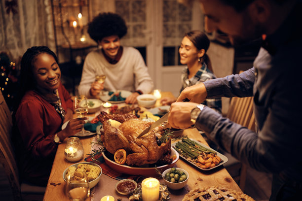 特写的人雕刻烤火鸡在感恩节大餐在餐桌上。图片下载