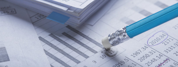 用橡皮擦会计文件，擦去文件上的污点，检查财务图表。银行、财务报告和财务审计的概念。图片下载