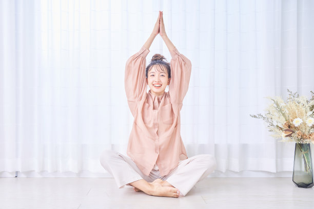 年轻女子在窗边伸懒腰图片下载