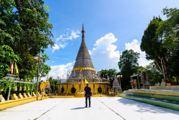 游客站在泰国Hat Yai的Phra Maha That Chedi Triphop Tri Mongkhon前面图片下载