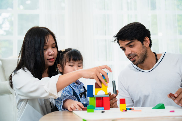 父母和女儿一起玩几何形状玩具图片下载