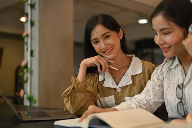 漂亮的女学生读书和做研究与她的朋友。教育、人、科技理念。图片下载