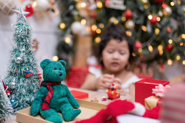 快乐的亚洲小女孩在圣诞节玩得很开心。孩子和父母在家里装饰圣诞树在假日。图片下载