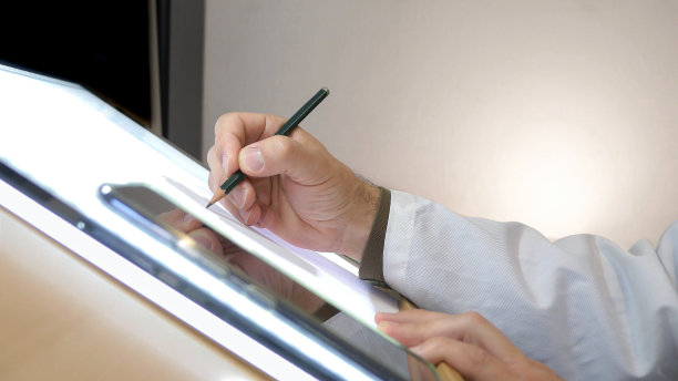 艺术家的手画在他的工作台上与光。图片下载