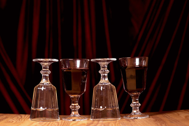 酒杯的红葡萄酒背景是别致的红色天鹅绒织物。浪漫晚餐的概念。一张照片里的红丝绒和激情。风格和品味的概念。图片下载