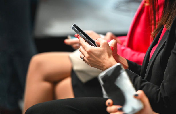 观众中的一位女士正在使用智能手机图片下载