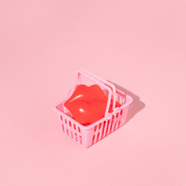 有创意的布局与红唇雕像在淡粉色背景购物篮。八九十年代的复古美学时尚概念。浪漫的情人节想法。图片下载