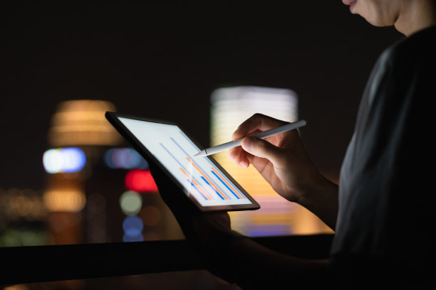 男子在城市灯光背景上使用平板电脑图片下载