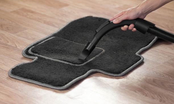 用吸尘器清洁汽车垫子。特写镜头图片下载