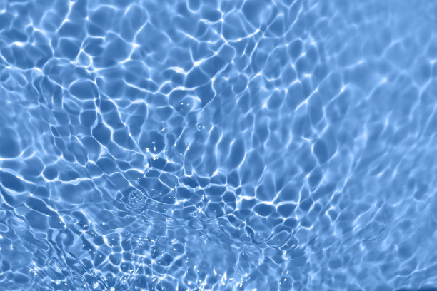 离焦模糊透明的蓝色清澈平静的水面纹理带有水花、气泡。粼粼碧水涟漪背景。游泳池的水面。蓝色的泡泡水闪闪发光。图片下载