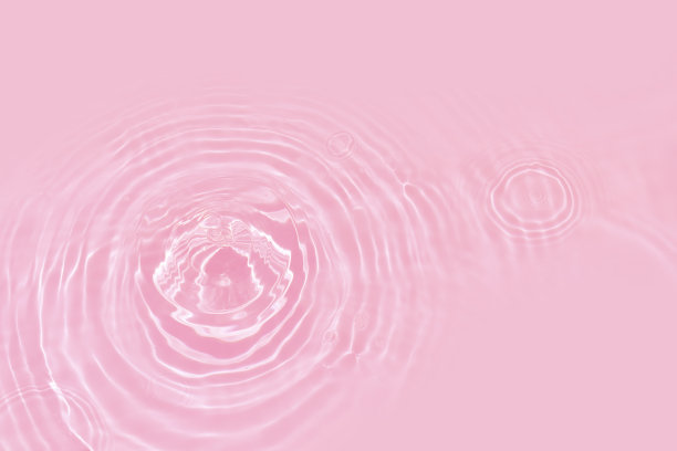 离焦模糊透明的粉红色颜色清澈平静的水面纹理与水花、气泡。闪亮的粉色水波纹背景。游泳池的水面。粉红色的泡泡水闪闪发光。图片下载