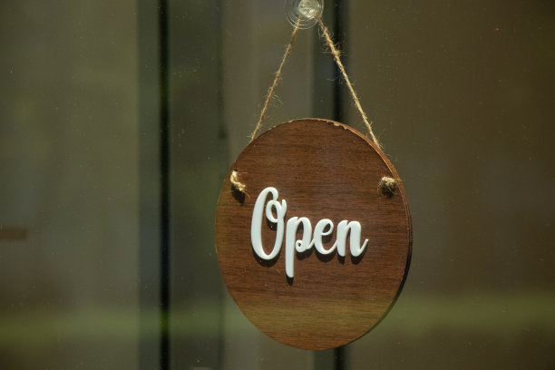 旧木牌匾挂在绳子上，上面的文字公开地挂在商店的玻璃橱窗上图片下载