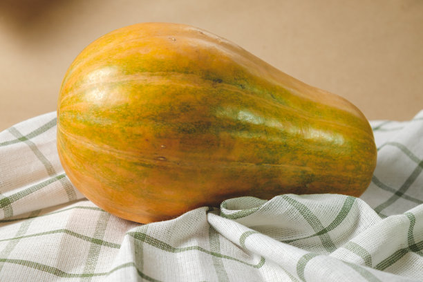 橙色，可食用的南瓜在毛巾上的牛皮纸背景与空间的文字。秋天的概念与南瓜。高质量的照片图片下载