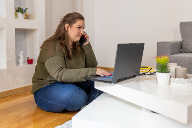 地板上的女人，用笔记本电脑打电话图片下载