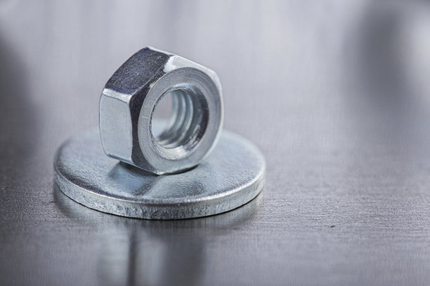 在钢板背景上设置不同的螺母，螺栓，螺钉，垫圈和钻头，丝锥和铣刀。锁匠工作协议。图片下载