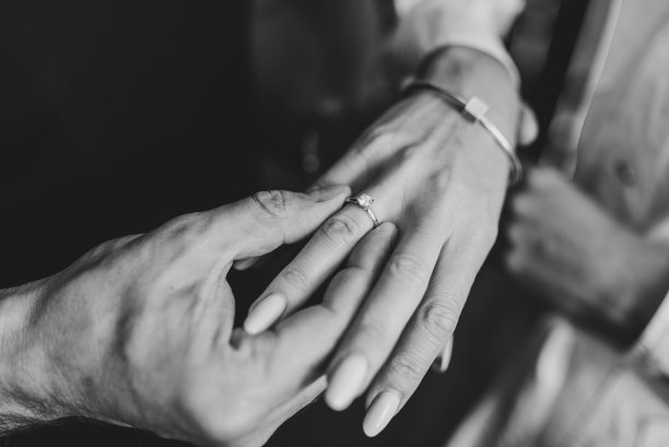 男子向女友求婚。恋爱中的男人把订婚戒指戴在女人的手指上。的建议。献上手和心。已订婚的情侣。黑白照片。前视图。发誓特写镜头。图片下载