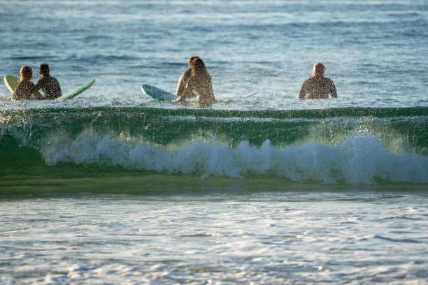 特写镜头的海浪冲击着海滩，背景是冲浪者图片下载