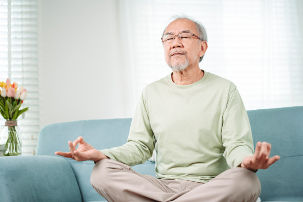 亚洲老人在家中客厅做瑜伽放松，成熟的退休快乐健康的生活方式理念。图片下载