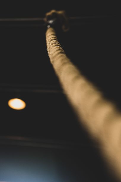 垂直低角度拍摄的在健身房里用于锻炼三头肌的绳子连接到金属杆上的照片图片下载