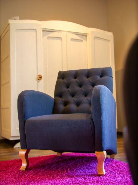 卧室里一张粉色地毯上的蓝色古董扶手椅的垂直照片图片下载