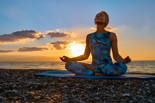 日出时分，年轻女子在海滩上练习瑜伽。和谐，幸福，冥想，健康的生活方式，放松，瑜伽，自我护理，正念冥想的概念。图片下载