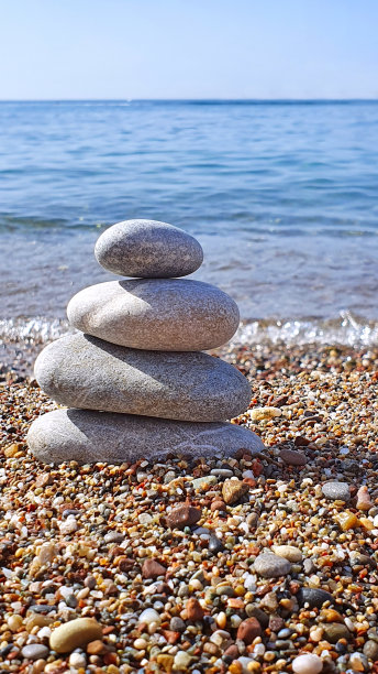 温泉石在海滩的沙子上保持平衡。图片下载