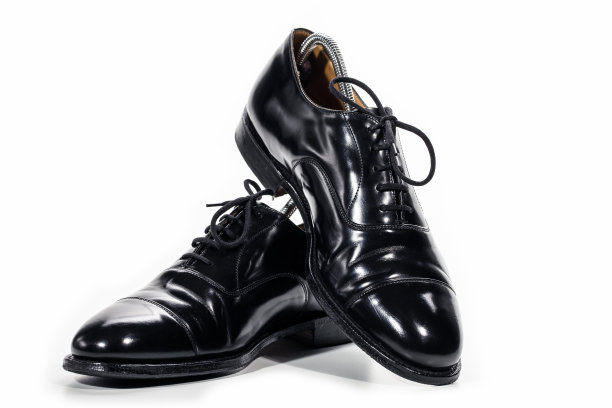 一对正式的男性时尚黑色抛光牛津皮革花边鞋放在一起超过白色。图片下载