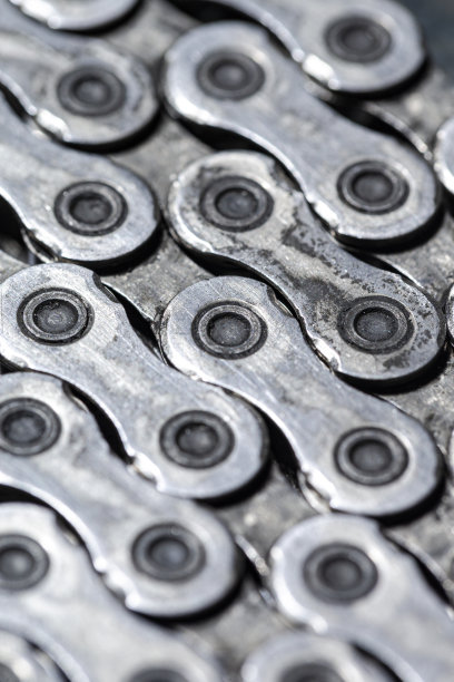 灰色瓷砖石质背景上闪亮肮脏油腻上油的自行车链作为金属自行车设备的一部分图片下载