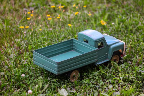 迷你蓝色苏联货车玩具绿草和彩色花朵的草地图片下载