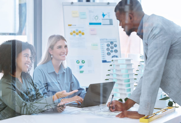 建筑师团队合作，建筑工程师或设计师在笔记本电脑上讨论，会议或规划三维模型建筑设计。有房地产开发经验的开发人员或具有房地产开发理念的多元化人员图片下载