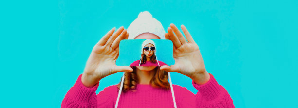 特写的妇女伸出她的手与智能手机在蓝色背景自拍图片下载