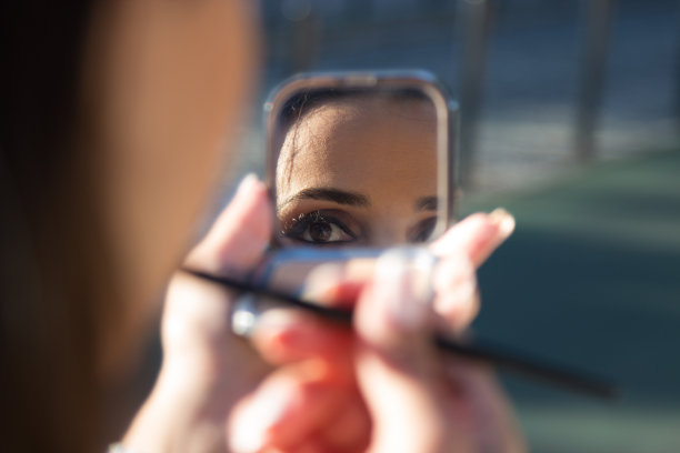 女人看着镜子的特写图片下载