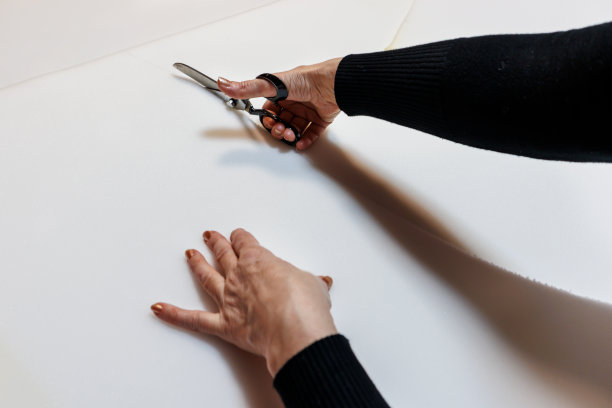 一位女裁缝正在用剪刀做新衣服。图片下载