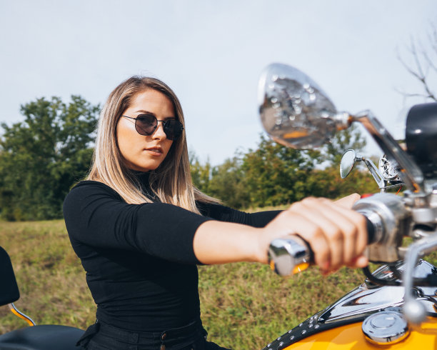 迷人的女人在摩托车上摆姿势图片下载
