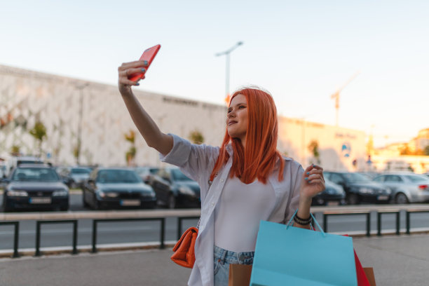 美丽的年轻红发女子在购物时自拍图片下载