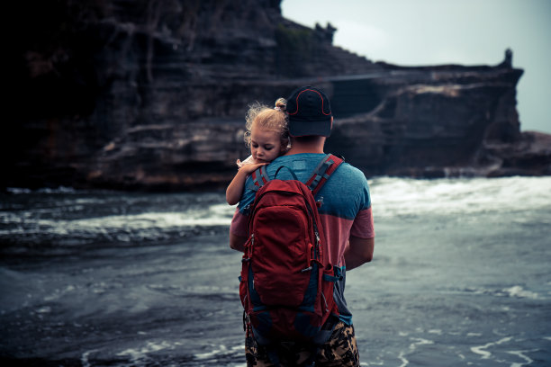 父亲抱着他的小女儿，满怀希望地望着远方的团聚概念图片下载