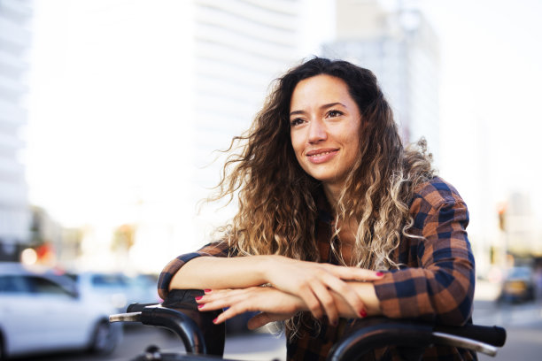 美丽的女孩在城市里骑自行车图片下载
