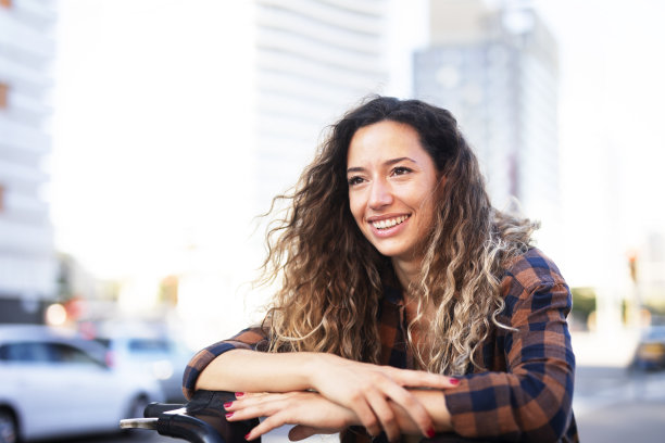美丽的女孩在城市里骑自行车图片下载