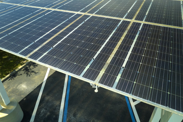 太阳能电池板安装在停车场停放的汽车，有效地产生清洁能源图片下载