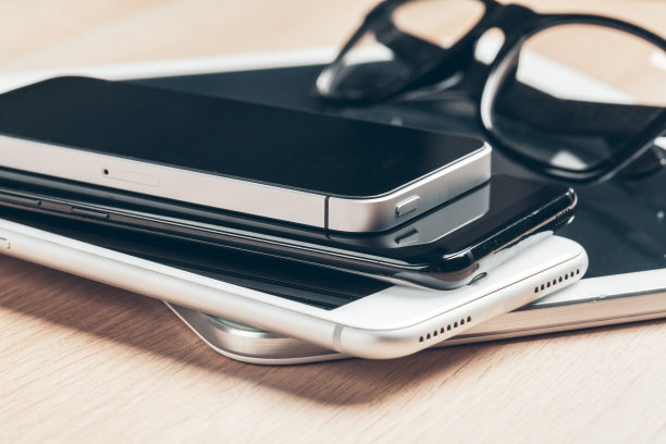 数字平板电脑和移动电话。木桌上的电子设备，特写。图片下载