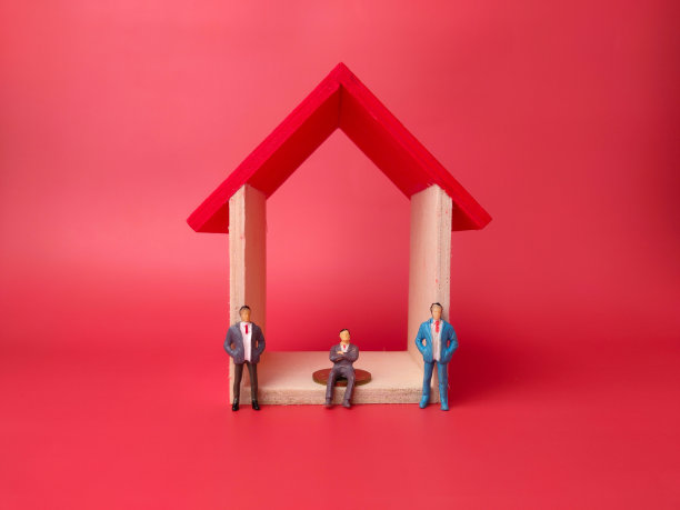 红色背景上有微型人物的玩具房子。经营理念。图片下载