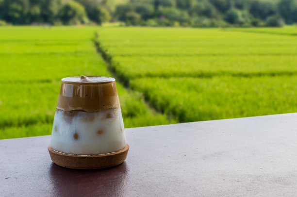 达尔戈纳咖啡在桌子上与模糊的稻田背景图片下载