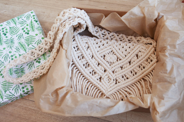 盒子里的手工流苏棉玫瑰挎包。女士用的环保棉绳袋。北欧风格的袋子。米色调配色，可持续时尚配饰。细节。近距离图像图片下载