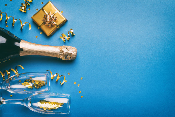 一瓶香槟与彩色闪光，五彩纸屑和礼品盒空间的文字彩色背景，顶视图。欢乐的圣诞节和生日庆典图片下载